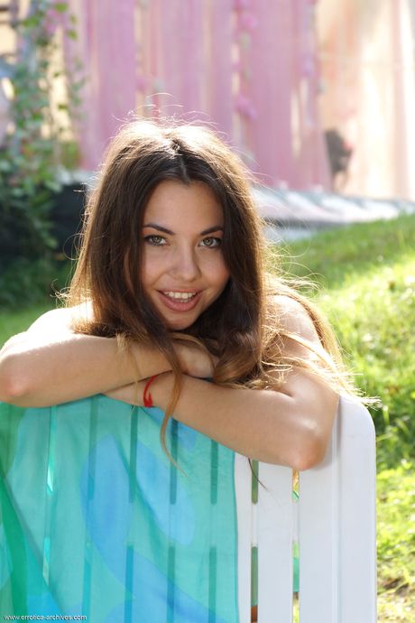 Lean teen Naomi G poses naked on a chair in the backyard during solo action