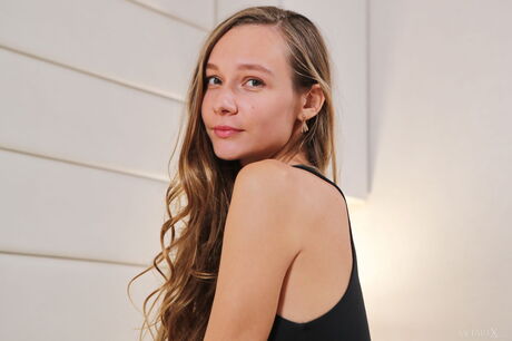 Petite teen Mirabella fingers her pussy after getting bare naked on a bed