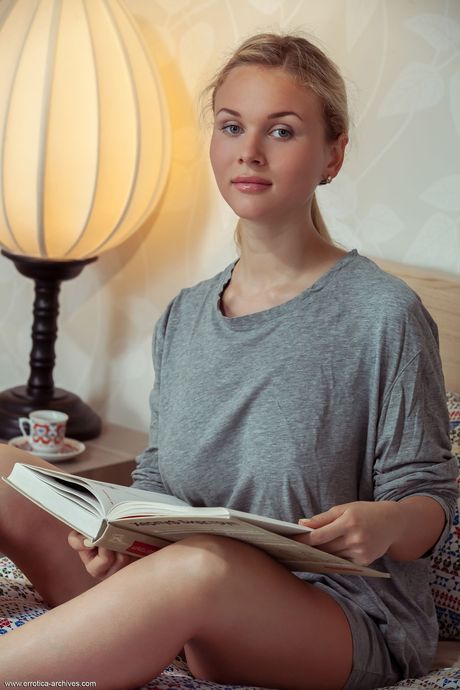 Blonde teen Caroline Abel highlights her bald pussy while naked on a bed