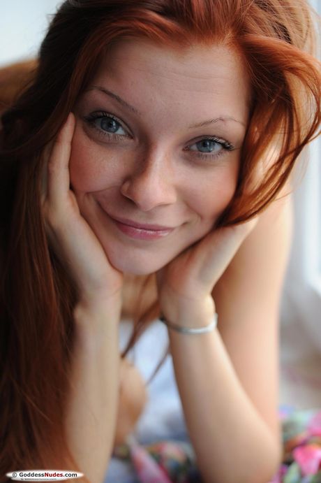 Skinny redhead Indi gets naked on a stool in a kitchen while wearing a dress