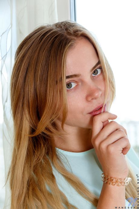 금발의 미녀 와네사가 누드 포즈를 취하기 위해 검은색 브래지어와 끈 팬티 세트를 벗고 있습니다.
