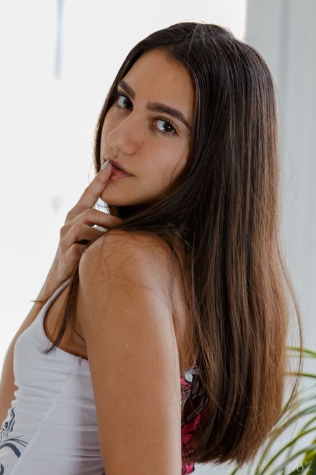 Charming teen Nelly J removes her underwear to pose nude in a kitchen