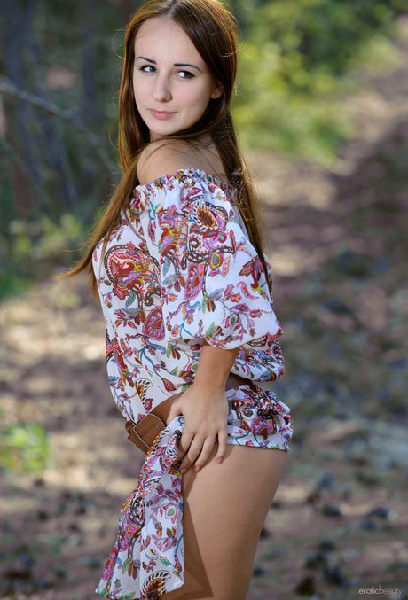 Nice teen Nastja models totally naked in a forest setting