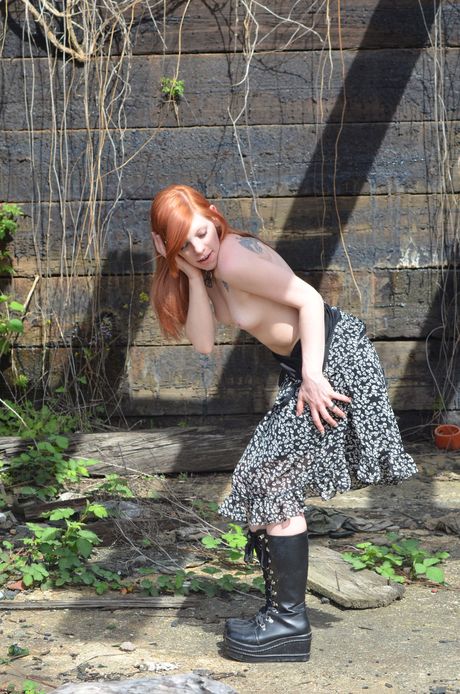 Redheaded teen Riann strips and masturbates her pussy outdoors