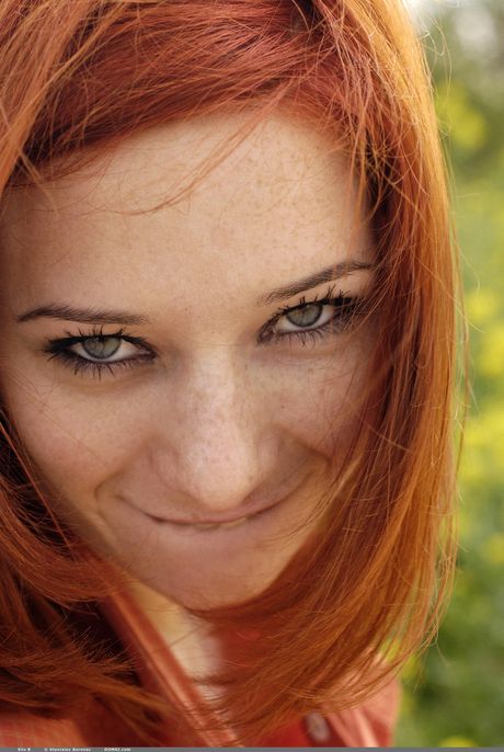 Skinny redhead Elis B reveals her naked form in the woods to show her small tits & hot ass