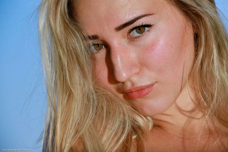 Young blonde Amaly takes off everything on a rocky outcropping