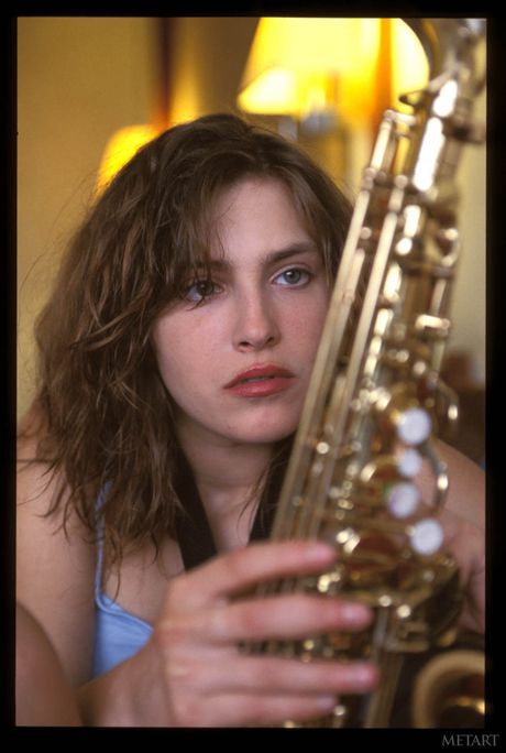 Asian girls Melinda A & Yuka B get naked in a bedroom while having fun