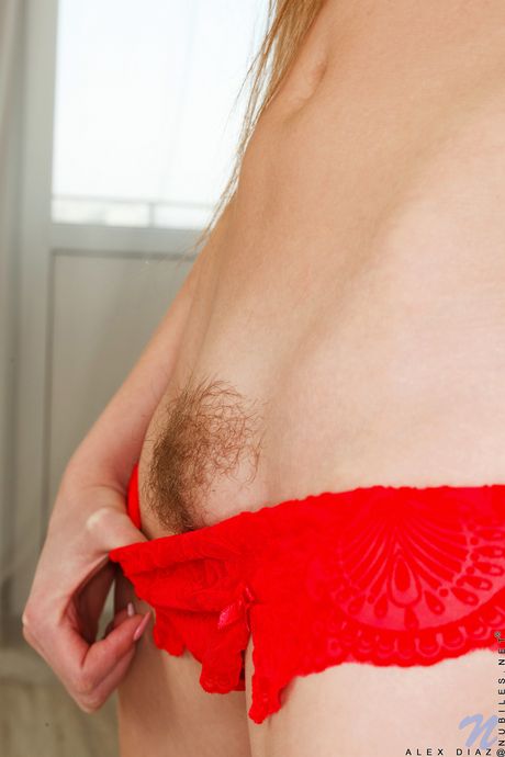 La rousse sexy Alex Diaz enlève une robe rouge avant de se masturber sur un lit
