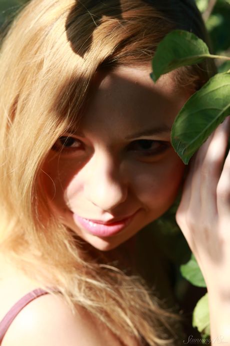 Young blonde Kimberly gets completely naked underneath an apple tree