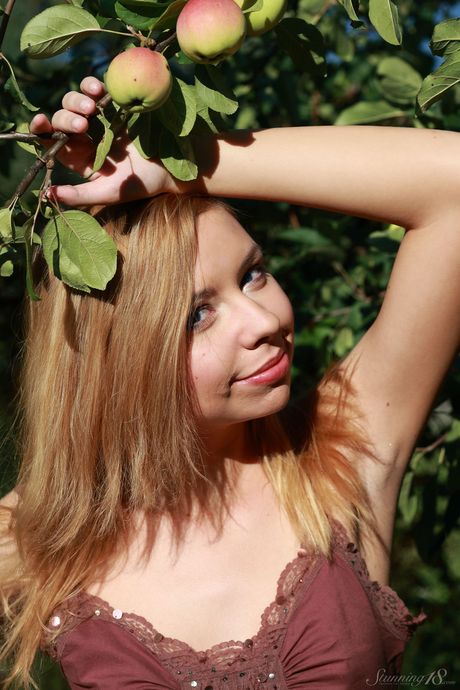 Young blonde Kimberly gets completely naked underneath an apple tree