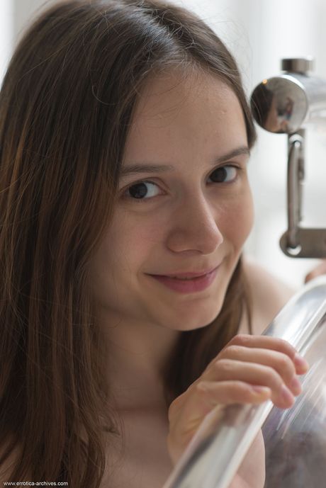 Svelte teen Eiby Shine shows her small tits & shaved pussy in a chair