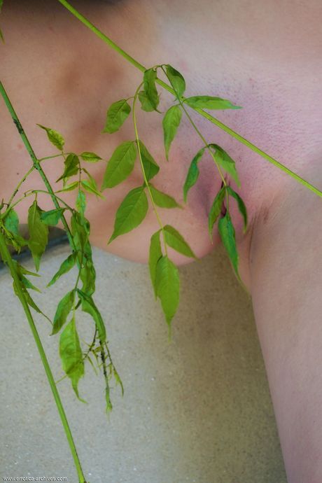 Teen model Leonella bares herself on a patch of grass in socks