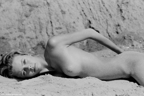 Skinny Russian beautiful Olga strips and poses nude in the sandy terrain