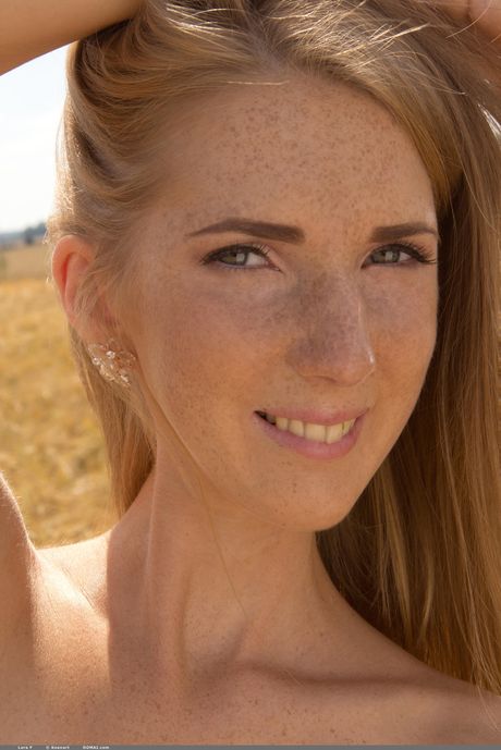 Young redhead Lera F models totally naked on a rocky outcropping