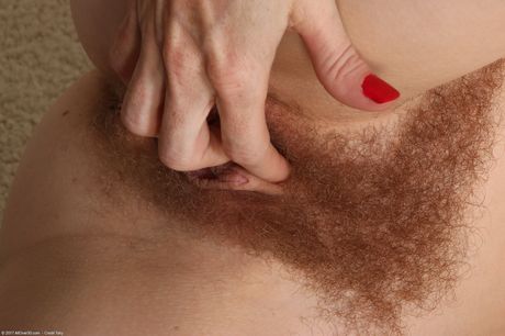 Mature redhead Evane Nordstern shows her hairy pussy and big booty