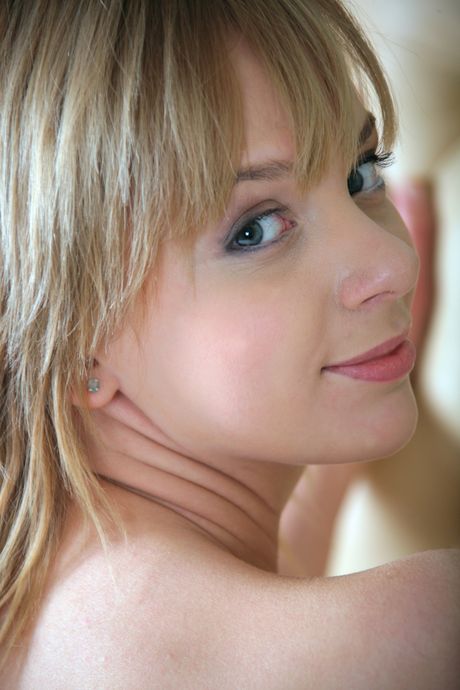 Thin teen with a slim figure July poses naked on a bed