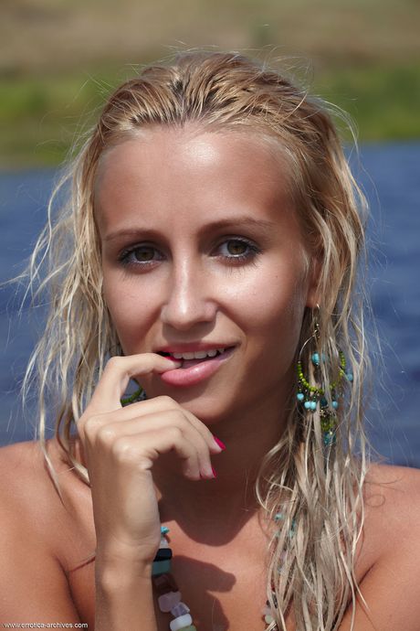 Petite teen Afina models totally naked on a sandy beach