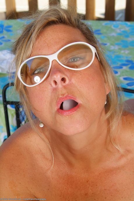 Blonde mature Cricket shows her big tits and plays with her holes poolside