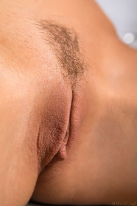 Petite teen Sybil A highlights her tight slit while totally naked on a bed