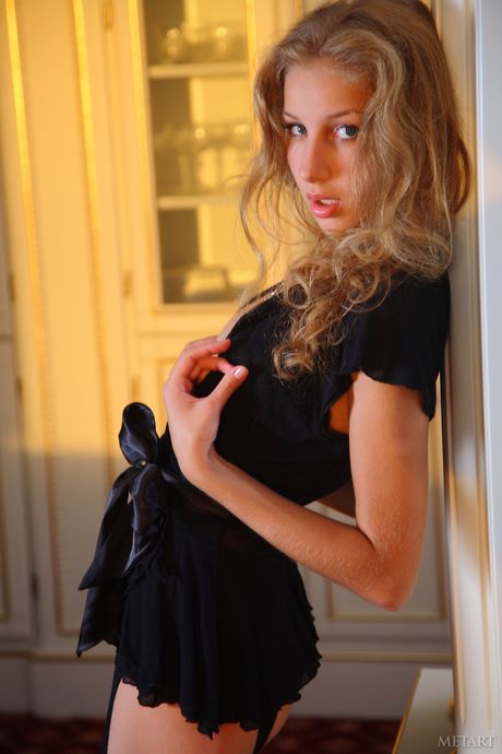 Blonde teen Erika F removes her lingerie and stockings to pose nude