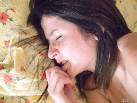 Engaging teen Mila K removes her pantyhose before masturbating on her bed