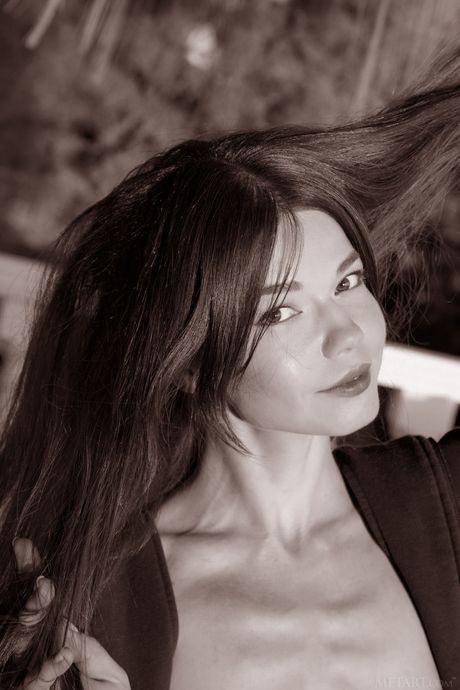 Nedda A removes her dress to pose nude on a balcony