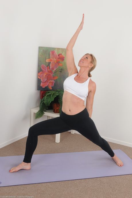 Mature woman Jenna Covelli gets naked while doing yoga in her living room