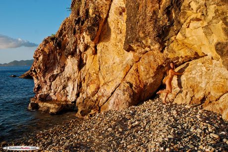 Young redhead Sarka highlights her landing strip pussy while naked on a beach