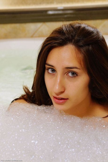 Winsome teen Leonella removes her bath towel before getting in a bathtub