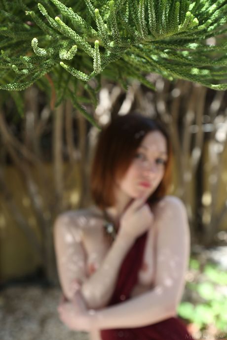 Ung rødhårete natt A går naken på en uteplass
