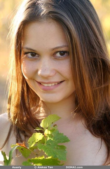 Thin teen Assoly gets naked on a blanket in a field