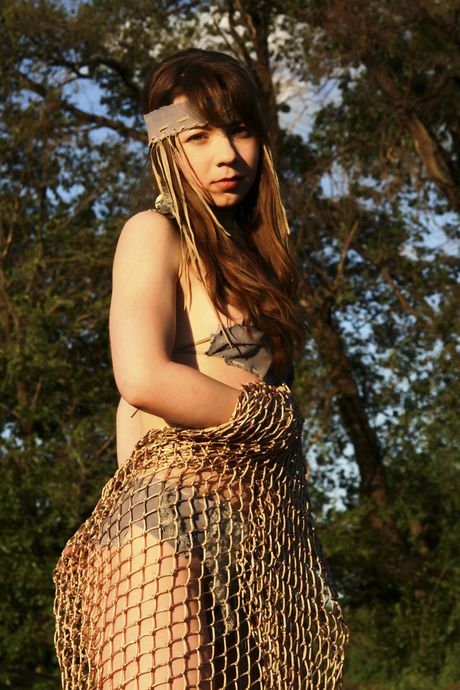 Lovely teen Laska A poses nude in a mesh top and heels in a forest