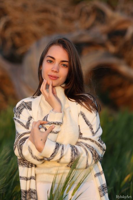 Young Brunette Sofy Bee fica nu em um campo de flores silvestres
