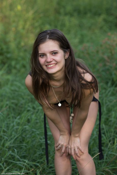 Petite teen Pola bares it all in high heels on a bank in the countryside