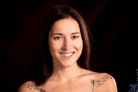 Mina slowly takes off her red dress and bra before sliding her hands