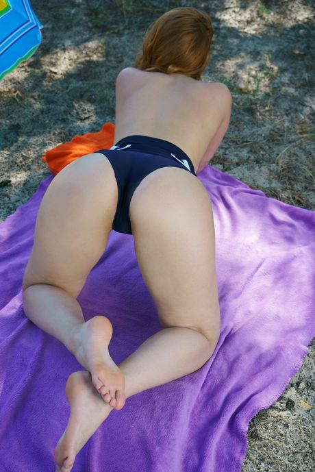 Redheaded teen Vos shows her big tits and poses naked in the backyard