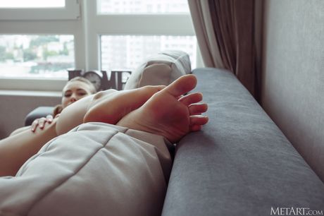 Pure teen Alaine removes her bikini and panties to pose nude on a sofa