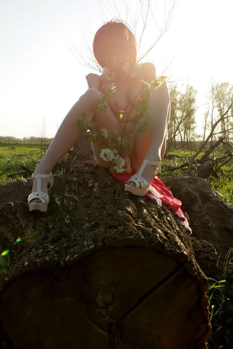 Smukke teen tanusha en strimler nøgne i et felt med blomster og poser i hæle
