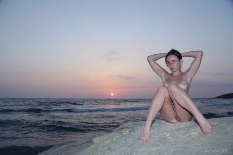 Brunette chick Jukos highlights her bald pussy while naked on a beach