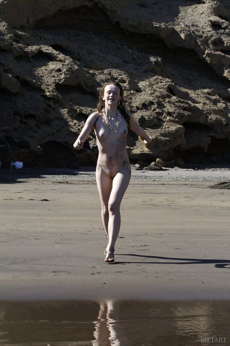 Svelte teen grima e viser hendes små bryster og poserer nøgen på stranden
