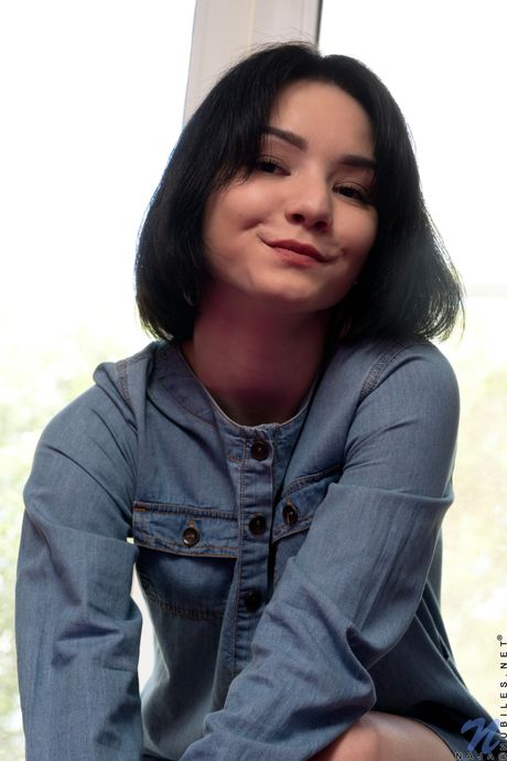 A adolescente atraente naja tira sua lingerie e apresenta sua buceta raspada em uma cama
