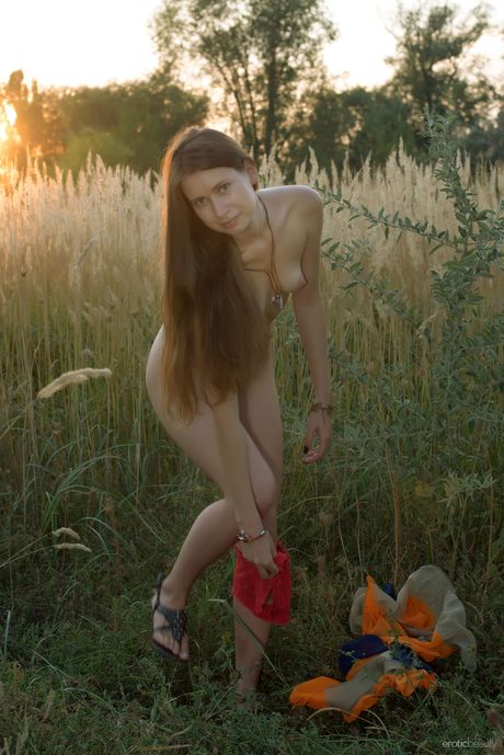 Nice teen Lady Di models totally naked in a field of crops by herself