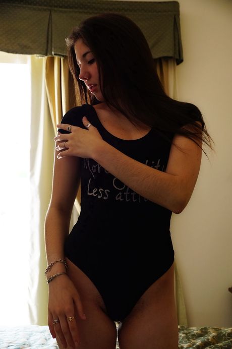 Magnetisk tonårsmargot B tar bort en svart bodysuit för att posera naken på hennes säng
