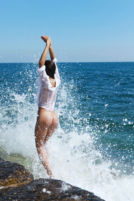 Delicate teen Olga M highlights her small tits and poses naked on the beach