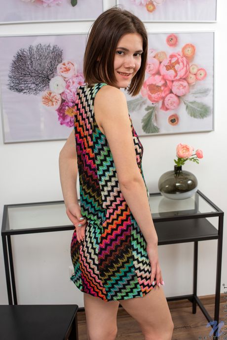 마른 십대 메테가 드레스를 벗고 의자에 앉아 자연스러운 가슴을 보여줍니다.
