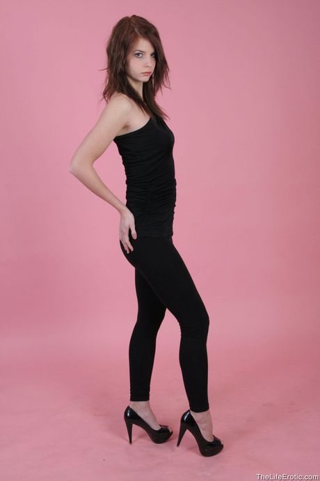 Young redhead Diana E removes her dress and panties to pose nude