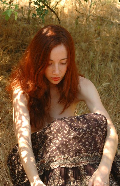 Redheaded babe Carmen A showing off sexy legs and big tits outdoors