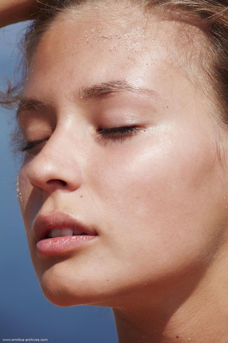 Young beauty Afrodita highlights her tight ass while naked on a beach