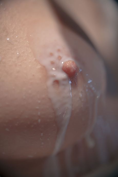 Brunette tiener Andrea P masturbeert met een fles melk in een badkuip
