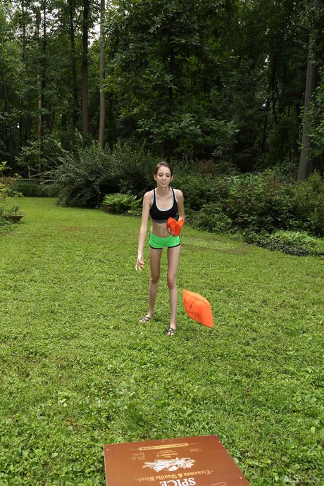 Svelte teen Aria Haze fists her pussy after playing a game of bean bag toss